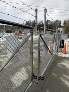 A commercial chain-link fence with barbed wire and a sliding gate installed by Wayside Fences in Brattleboro, VT.