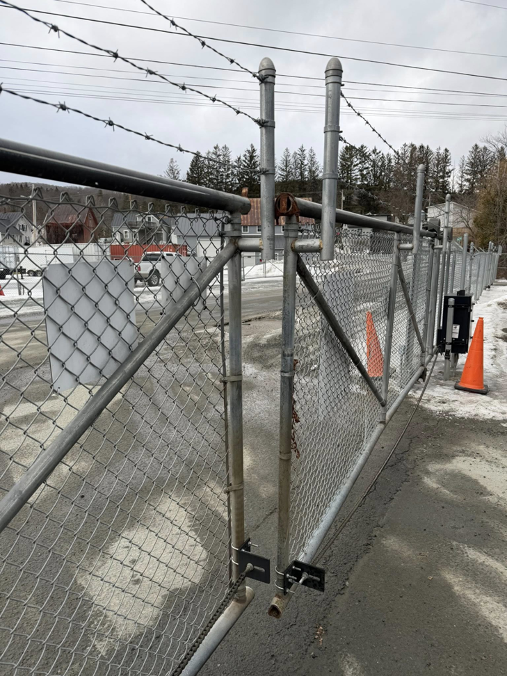 A commercial chain-link fence with barbed wire and a sliding gate installed by Wayside Fences in Brattleboro, VT.