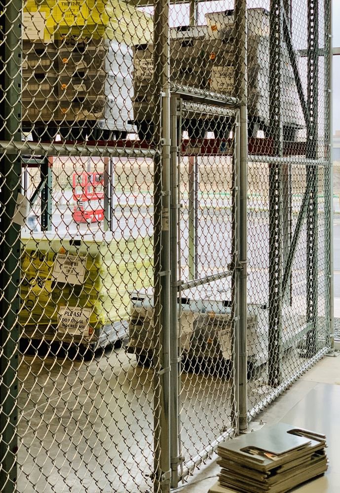 A commercial chain link fence with a gate inside a warehouse installed by 2 Guys & A Girl Lawn Care in Thornton, CO.