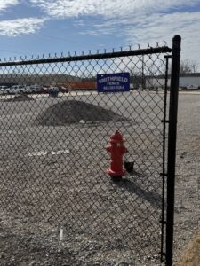 A commercial chain-link fence with a Smithfield Fence sign installed in Crowder, MS.