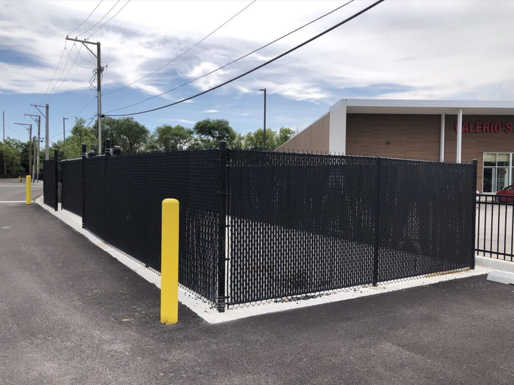 A black chain-link fence with privacy slats around a commercial property by Superior Custom Fence Inc. in Chicago, IL.