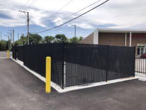 A black chain-link fence with privacy slats around a commercial property by Superior Custom Fence Inc. in Chicago, IL.