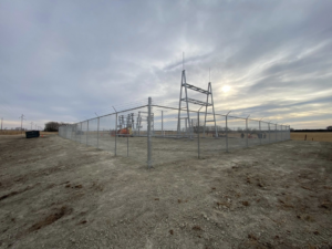 A commercial chain-link security fence with barbed wire installed around a site by Big Red Fencing LLC in Waverly, NE.