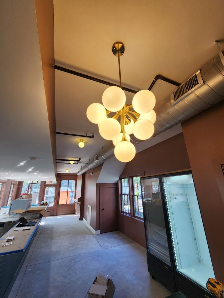 A large modern chandelier and exposed electrical conduit in a commercial space by ALC Electric LLC in Goose Creek, SC