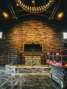 Electricians installing a large commercial chandelier in a building, demonstrating services by Jackson Electrical Contractors in Jackson, TN.