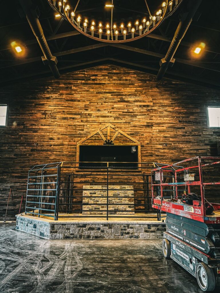 Electricians installing a large commercial chandelier in a building, demonstrating services by Jackson Electrical Contractors in Jackson, TN.