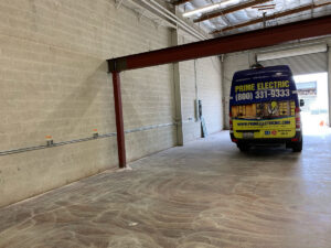 Commercial electrical conduit installation along a brick wall inside a building by Prime Electric in Bellevue, WA.