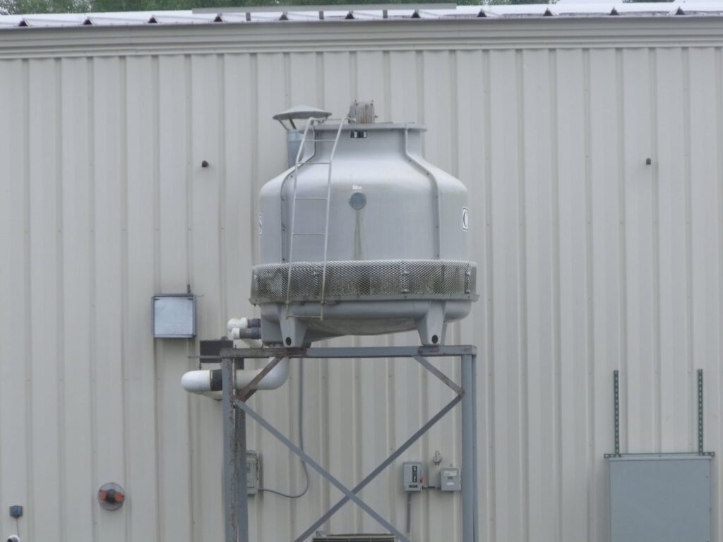A commercial cooling tower installed on a stand outside a building by Action Mechanical LLC in Eau Claire, WI.
