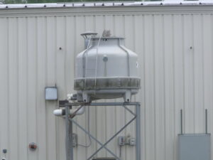 A commercial cooling tower installed on a stand outside a building by Action Mechanical LLC in Eau Claire, WI.