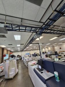 Overhead cable trays with blue data cabling installed in a commercial space by Bee Thumb Electric in North Highlands, CA.