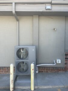 A commercial dual-fan outdoor HVAC unit installed by Omega Air Solutions in West Des Moines, IA.