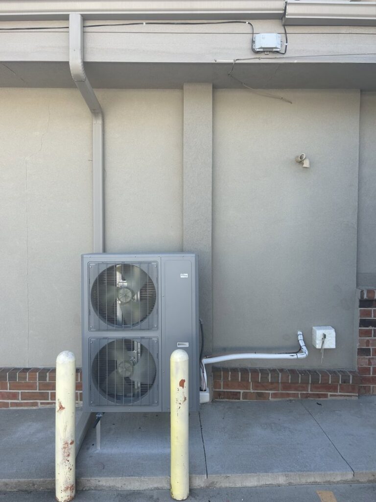 A commercial dual-fan outdoor HVAC unit installed by Omega Air Solutions in West Des Moines, IA.