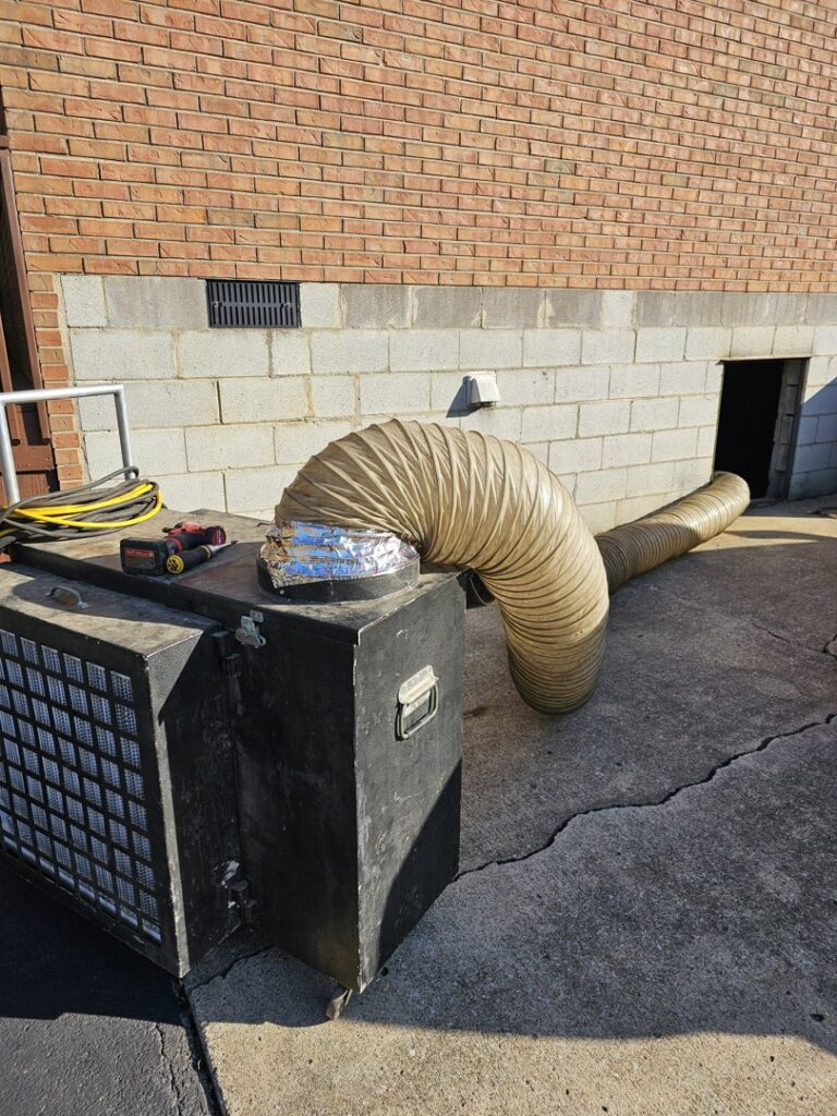 A commercial duct cleaning or sealing setup with large flexible ducting outside a building by Aces of Air Inc. in Georgetown, KY.