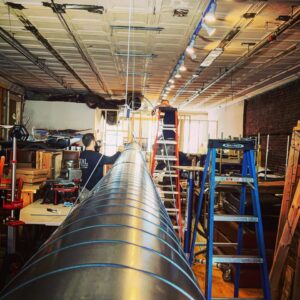 HVAC technicians from EML Mechanical installing large spiral ductwork in a commercial building in Boston, MA.