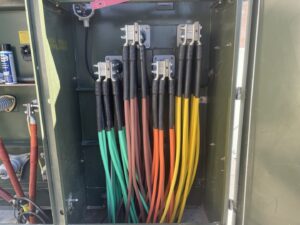 Interior view of a commercial electrical cabinet with multiple thick cables, indicating professional wiring by Big Red Electric Company in San Antonio, TX.