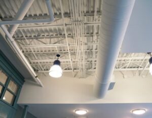Commercial electrical conduit, wiring, and pendant lighting fixtures installed on a ceiling by Howe Electric Inc in Tea, SD.