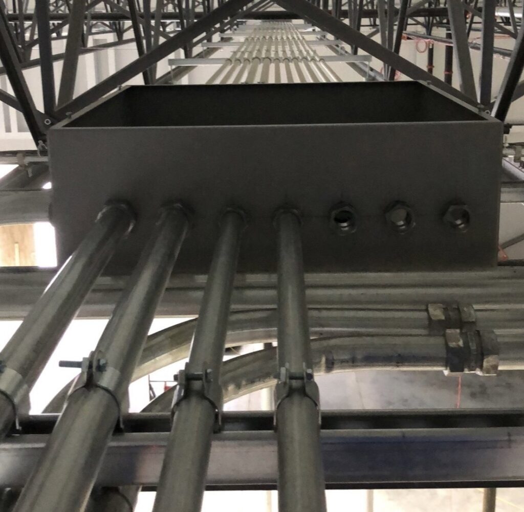 Electrical conduits and junction boxes installed along a ceiling structure in a commercial building by Lighten Up Electric, LLC in Cranston, RI.