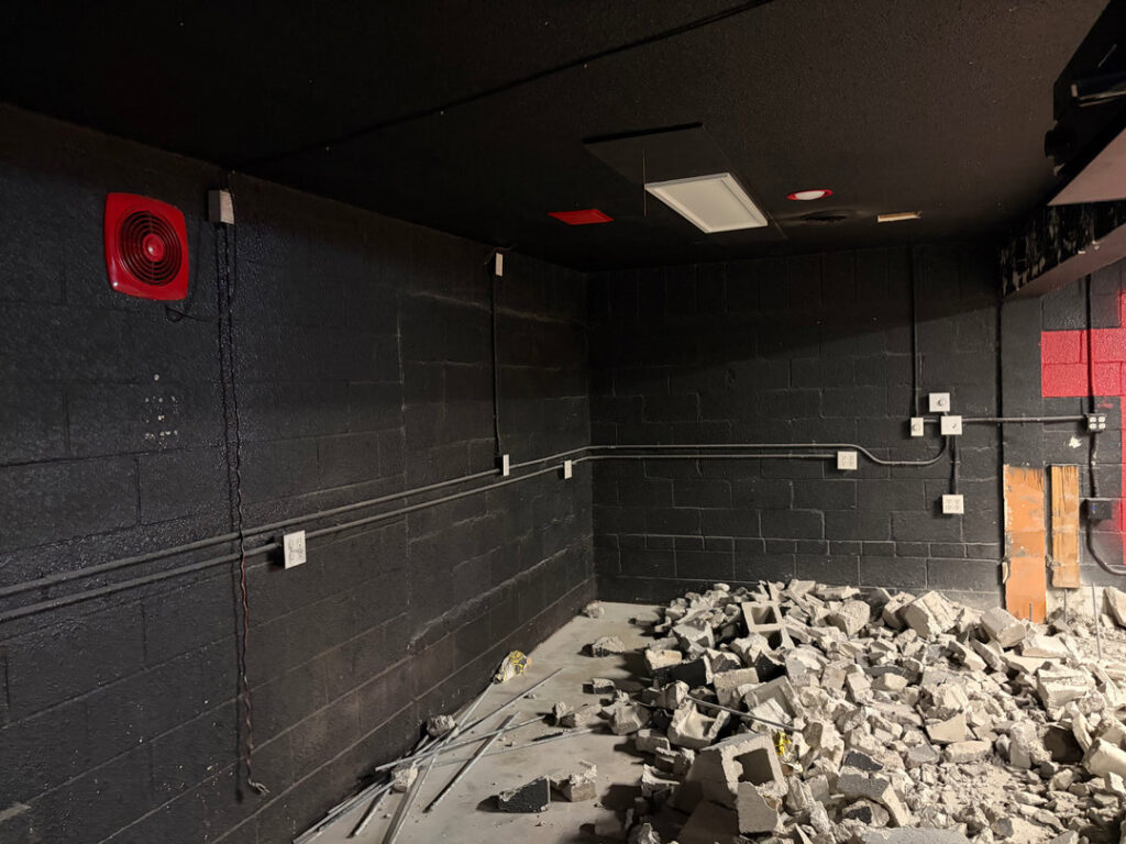 Commercial electrical conduit and box installation on a black brick wall by Tier 1 Electric in Boise, ID.