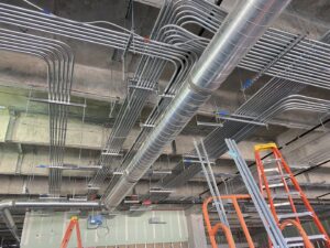Extensive commercial electrical conduit installation on a ceiling in a building under construction by Ultralight Electric in Houston, TX.