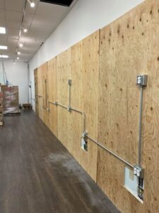 Commercial electrical conduit and outlets installed on a plywood wall by Signature Electric INC. in Cleveland, OH