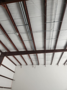 Commercial electrical conduits and lighting fixtures installed on a ceiling by Overton Power Solutions Electric in Hephzibah, GA