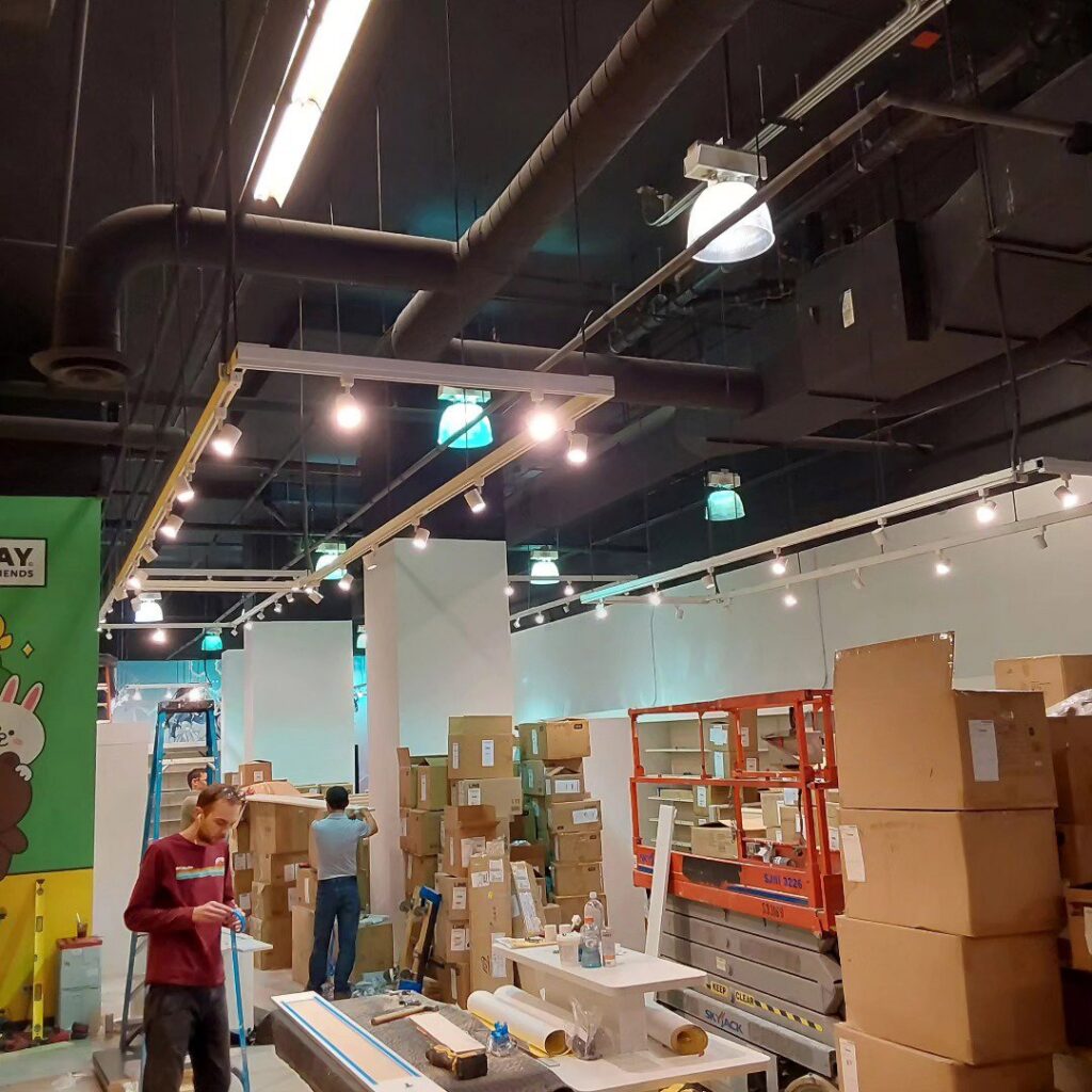 Commercial electrical installation in progress with track lighting and workers at Flavin Electric, LLC in Chicago, IL