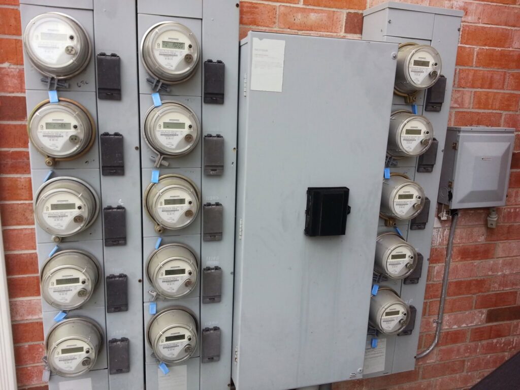 Multiple commercial electrical meters and a main panel on a brick building, serviced by Sterling Wiring Solutions in Pearland, TX.