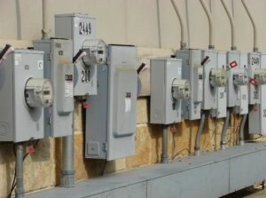 A row of commercial electrical meters and service panels installed on an exterior wall by Affordable Electric, LLC in Kearney, NE.