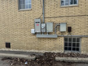 Multiple outdoor electrical meters and a Generac transfer switch installed by Electric R US LLC in Dearborn, MI.