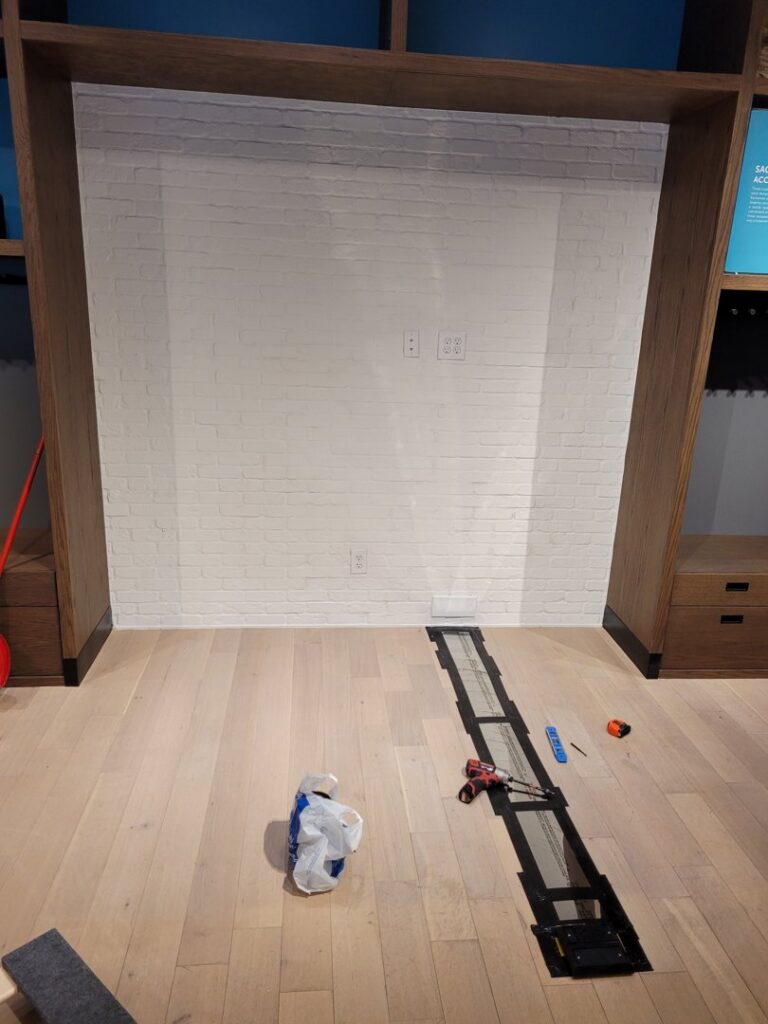 A commercial wall with multiple electrical outlets and a floor trench for wiring, installed by KS Retail Solutions in Victoria, TX