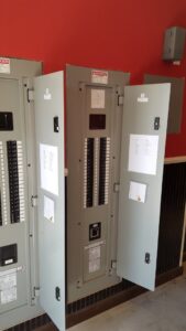Large commercial electrical panel with open circuit breakers and wiring installed by Red Earth Electric LLC in Oklahoma City, OK.