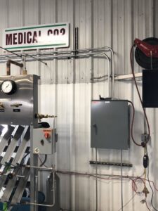 Commercial electrical panel and conduit installation with a 480-volt warning sign by AC-DC Electric in Severance, CO.