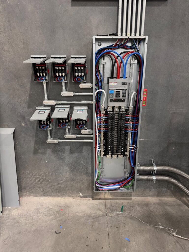 A large commercial electrical panel installation with multiple conduits and disconnects by Industrial Edge Electrical in Gilbert, AZ.