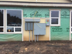 Multiple exterior electrical panels installed on a commercial building under construction by Johnsen Electric Inc in Springfield, OR.