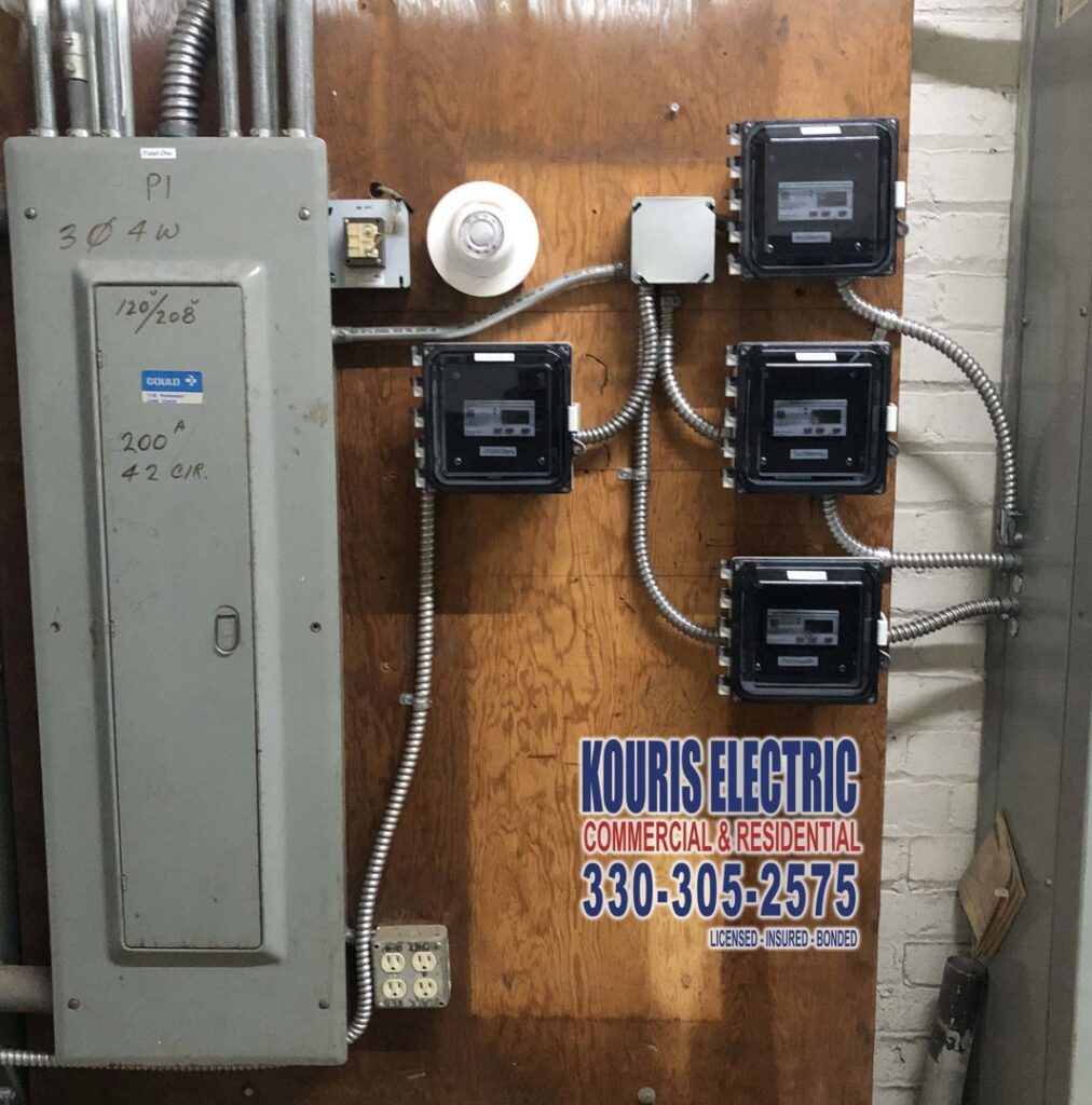 A commercial electrical panel with multiple sub-meters installed on a wooden wall by Kouris Electric LLC in Canton, OH.