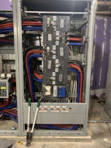 Detailed view of a commercial electrical panel with complex wiring and components, installed by P&E Electric in Denver, CO.