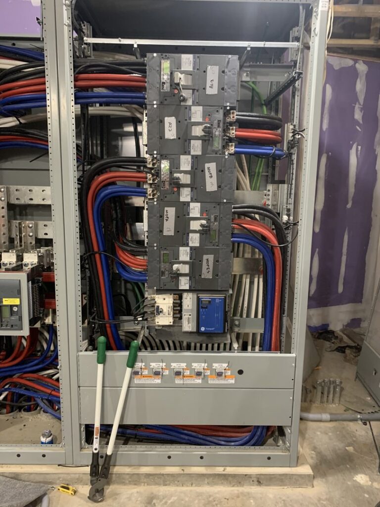 Detailed view of a commercial electrical panel with complex wiring and components, installed by P&E Electric in Denver, CO.