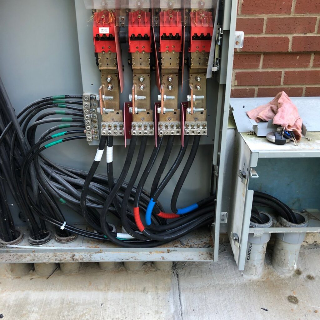 Close-up of a commercial electrical panel with thick cables and busbars, showcasing wiring work by Rush Electric Memphis, TN.