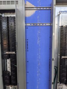 Interior view of a commercial electrical panelboard with numerous circuit breakers, handled by GOBE LLC in Columbia, MO.