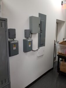 Multiple electrical panels and boxes mounted on a commercial wall, installed by KS Retail Solutions in Victoria, TX