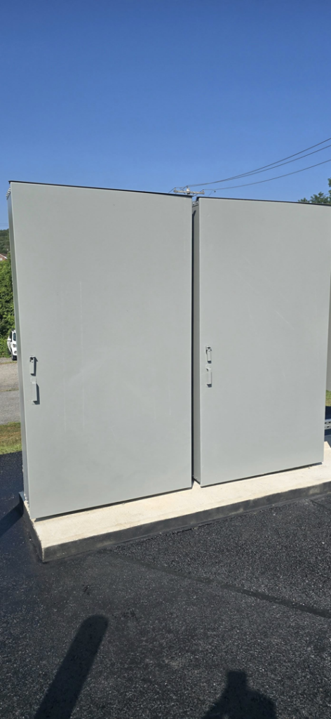 Two large grey commercial electrical panels installed on a concrete pad by Pittsburgh Electric & Maintenance in Pittsburgh, PA