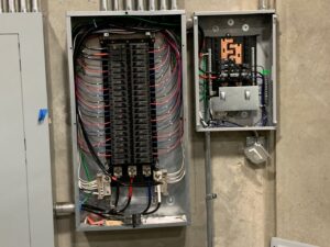 Two open commercial electrical panels with complex wiring by Gilmore Electrical in Saint Louis, MO