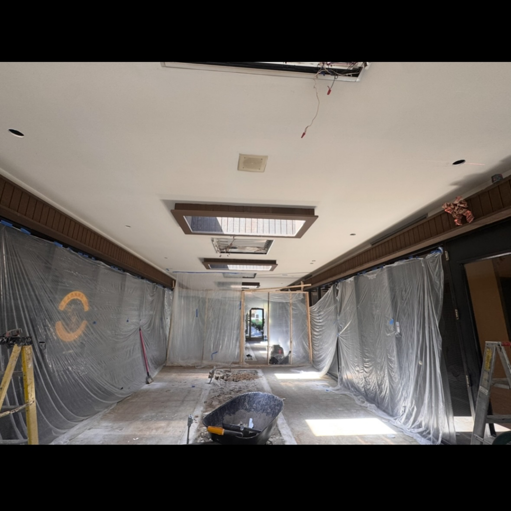 Commercial electrical renovation in progress with exposed wiring and plastic sheeting in a hallway by Mechatronics LLC in Memphis, TN.