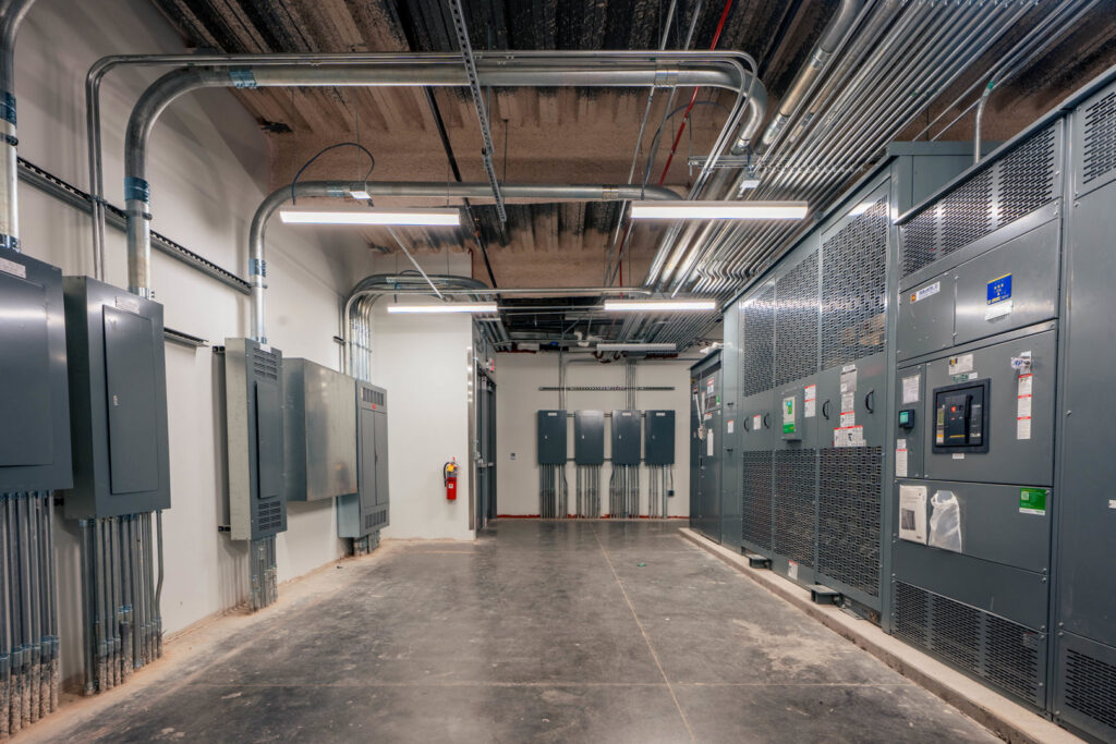 A commercial electrical room with multiple panels, conduits, and large equipment installed by BESCO in Knoxville, TN.