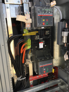 A close-up view inside a commercial electrical switchgear showing heavy-gauge wiring and circuit breakers installed by Mcgehee Electric, LLC in Montgomery, AL.