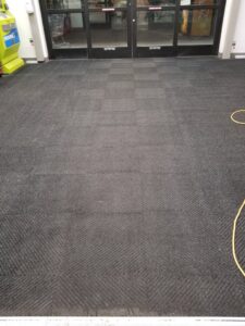 A commercial entrance area featuring dark gray carpet tile installation by Heather Mountain Flooring in Layton, UT.