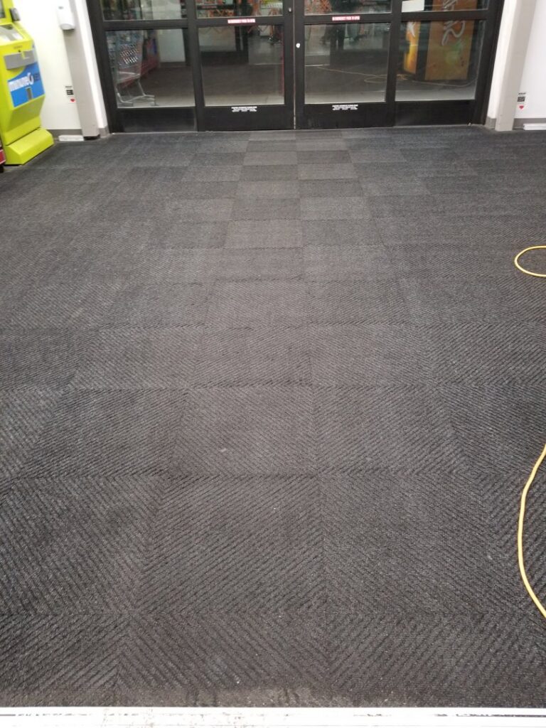 A commercial entrance area featuring dark gray carpet tile installation by Heather Mountain Flooring in Layton, UT.