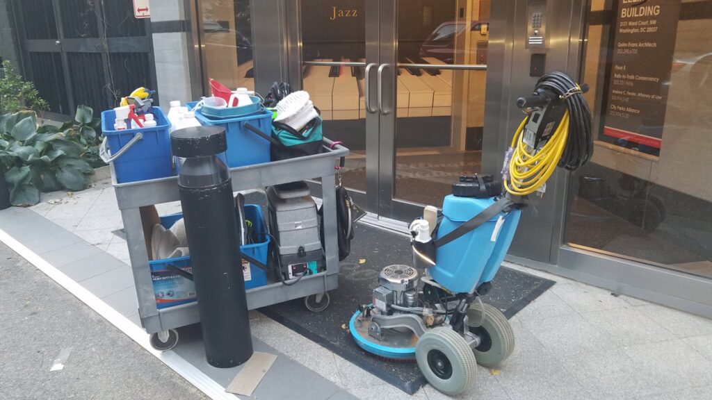 Commercial floor cleaning equipment and cart outside a building by My Carpet Cleaning & Restoration Services in Silver Spring, MD.
