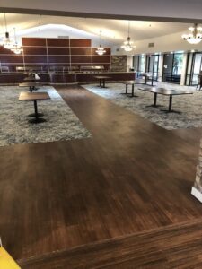 A large commercial space featuring a combination of dark wood-look flooring and patterned carpet, installed by Anaheim Carpet and Flooring in Anaheim, CA.