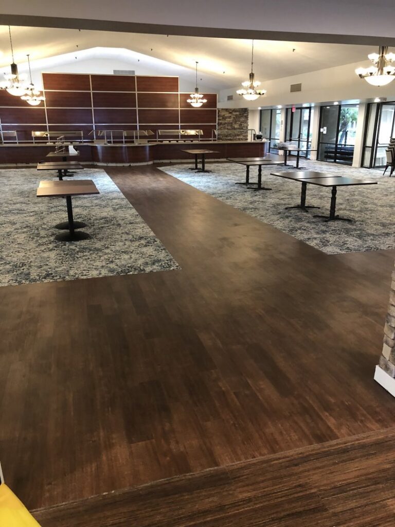 A large commercial space featuring a combination of dark wood-look flooring and patterned carpet, installed by Anaheim Carpet and Flooring in Anaheim, CA.